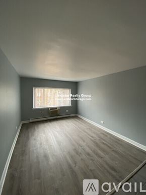 Chicago apartment for rent - A room with wooden flooring and a window with blinds.