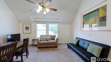 San Marcos apartment for rent - A living room with a black couch, a television, and a painting on the wall.
