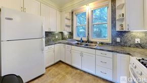 San Marcos apartment for rent - A kitchen with white cabinets and a black chair.