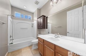 Corona apartment for rent - A bathroom with a white tub, sink, and toilet.