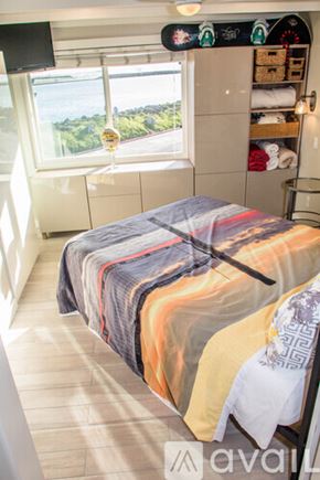 San Diego condo for rent - A bedroom with a bed covered in blankets and a window overlooking a green landscape.