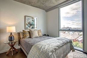 Chicago apartment for rent - A bedroom with a large bed and a view of the city.