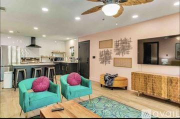 Pensacola apartment for rent - A living room with two green chairs and a wooden coffee table.