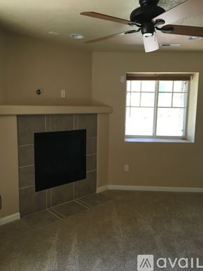 Aurora house for rent - A living room with a fireplace and a ceiling fan.
