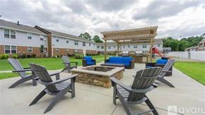 Newport News apartment for rent - A patio with a fire pit and chairs.