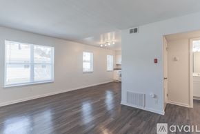 Newport News apartment for rent - A spacious room with wooden floors and white walls.