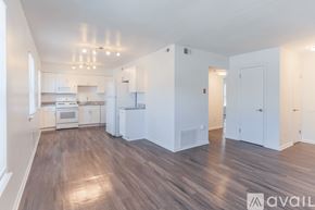 Newport News apartment for rent - A spacious kitchen with white cabinets and a wooden floor.