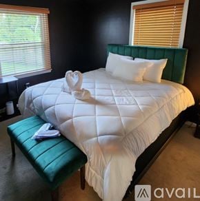 Fort Washington house for rent - A white bed with a green headboard and a white pillow.