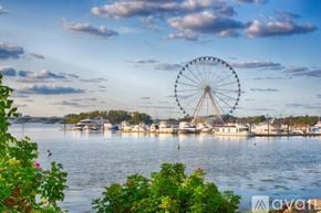 Fort Washington house for rent - A ferris wheel is in the background of a body of water with boats and buildings.