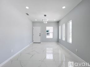 Edinburg apartment for rent - A spacious room with marble flooring and a white door.
