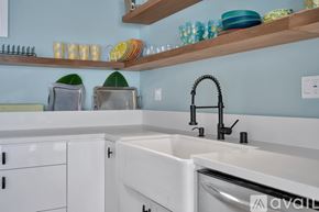 El Segundo house for rent - A kitchen with a white sink and a wooden shelf above it.