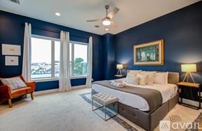 Houston townhouse for rent - A bedroom with a large bed and a ceiling fan.