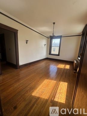 Oswego apartment for rent - A room with wooden floors and a window with a view of a building outside.