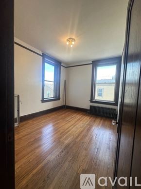 Oswego apartment for rent - A room with wooden flooring and two windows.