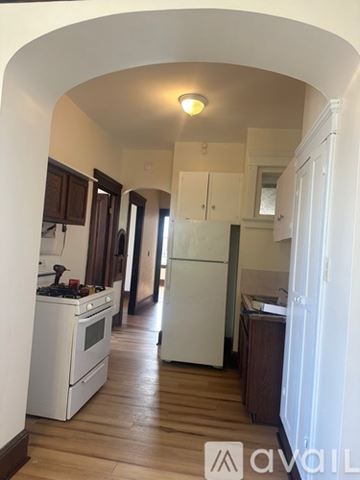 Oswego apartment for rent - A kitchen with white appliances and wooden floors.