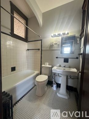 Oswego apartment for rent - A bathroom with a white toilet, sink, and bathtub.