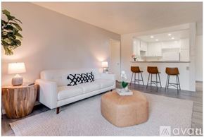 Azusa apartment for rent - A living room with a white couch, a wooden side table, and a grey rug.