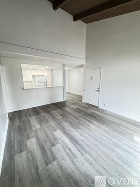 Azusa apartment for rent - A bedroom with a large bed, a wooden nightstand, and a plant on the bedside table.