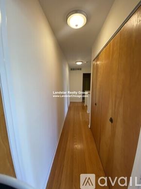 Highland Park apartment for rent - A long hallway with wooden floors and doors on the right side.