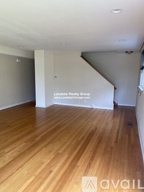 Highland Park apartment for rent - A room with wooden flooring and a white wall with a Landstar Realty Group logo.