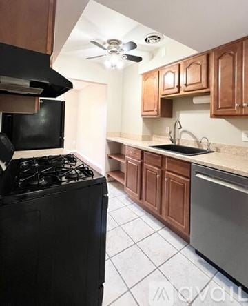 Shaker Heights apartment for rent - A kitchen with a black stove top oven and wooden cabinets.