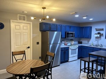 Ocala apartment for rent - A kitchen with blue cabinets and a stainless steel refrigerator.