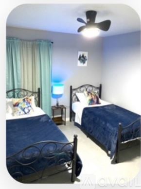 Ocala apartment for rent - A bedroom with two beds and a ceiling fan.