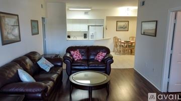Fort Myers condo for rent - A living room with a brown leather couch and a coffee table.