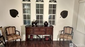 Fort Myers condo for rent - A wooden desk with a chair on each side and two decorative objects on top.