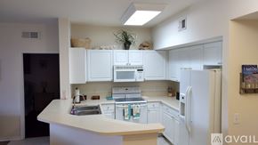 Fort Myers condo for rent - A kitchen with white cabinets and appliances.