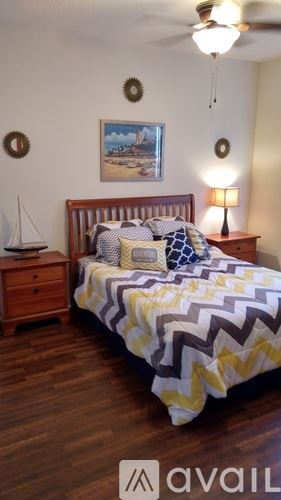 Fort Myers condo for rent - A bedroom with a bed, a nightstand with a lamp, and a painting on the wall.