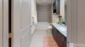 Dallas apartment for rent - A bathroom with a toilet, sink, and a rug on the floor.