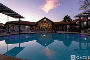Fort Worth apartment for rent - A large swimming pool in front of a house with a sunset in the background.