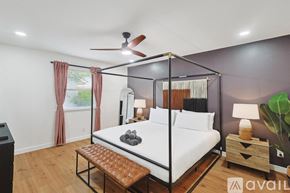 Dallas house for rent - A bedroom with a four poster bed and a ceiling fan.