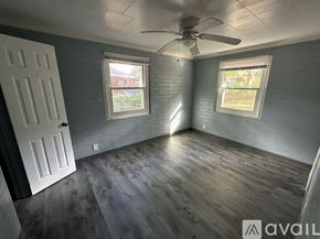 Rocky Mount apartment for rent - A room with a ceiling fan and two windows.