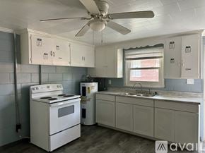 Rocky Mount apartment for rent - A kitchen with a white stove and a fan on the ceiling.