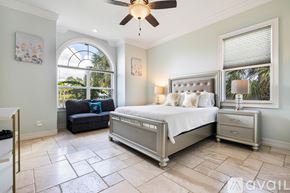 Port Charlotte house for rent - A bedroom with a large bed and a ceiling fan.