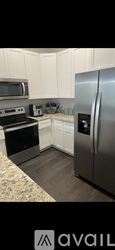 New Orleans house for rent - A kitchen with white cabinets and a stainless steel refrigerator.