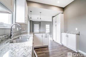 Columbiana house for rent - A kitchen with a marble countertop and white cabinets.