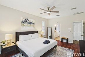 Lake Dallas house for rent - A bedroom with a large bed and a ceiling fan.