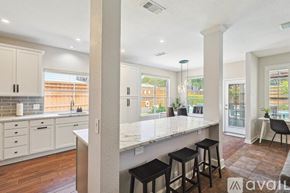 Lake Dallas house for rent - A kitchen with white cabinets and a marble countertop.