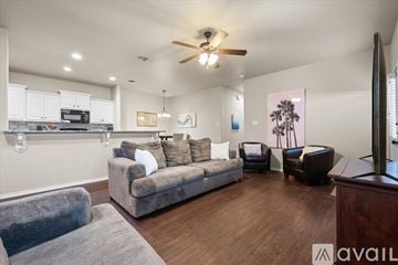 Wolfforth apartment for rent - A living room with a grey couch and a wooden floor.