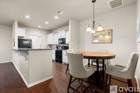 Wolfforth apartment for rent - A kitchen with a bar area and a dining table with chairs.