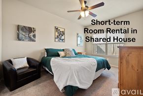 Wolfforth townhouse for rent - A bedroom with a bed, chair, and ceiling fan is available for short-term room rental in a shared house.