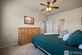 Wolfforth townhouse for rent - A bedroom with a bed, dresser, and ceiling fan.