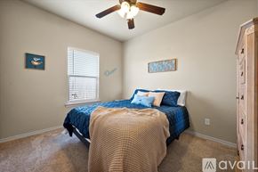 Wolfforth condo for rent - A bedroom with a bed, a ceiling fan, and two pictures on the wall.