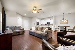Wolfforth condo for rent - A spacious living room with a brown sofa set and a ceiling fan.