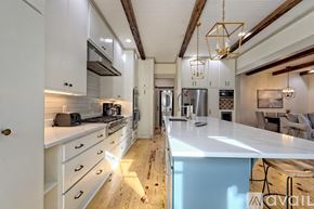 Clayton house for rent - A modern kitchen with white cabinets and a wooden floor.