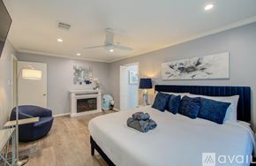 Houston house for rent - A bedroom with a large bed and a blue chair.
