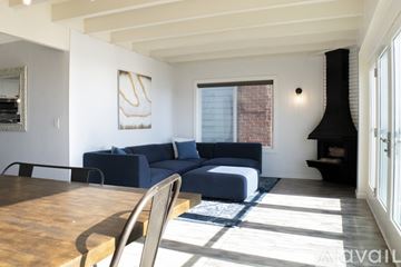 Huntington Beach condo for rent - A living room with a blue couch and a wooden table.